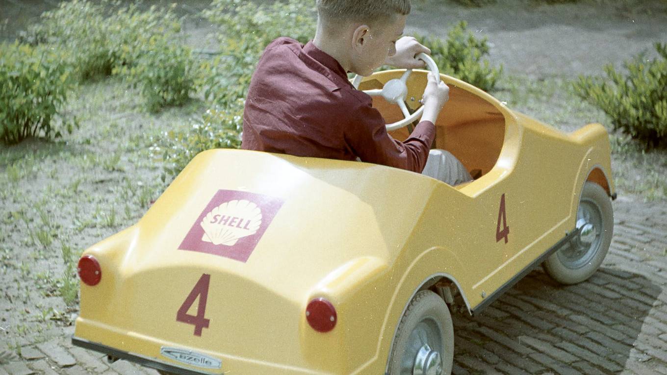 Jongen in gele Shell wagen